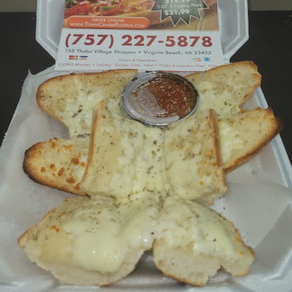 Cheesy garlic bread with marinara sauce in a white takeout container from Town Center Pizzeria.